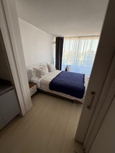 Un dormitorio pequeño con una cama y una ventana. en RentApartNuevadeLyon12, en Santiago