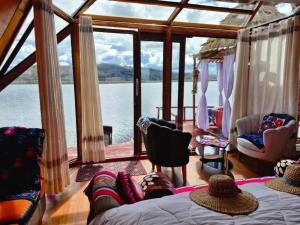 een persoon op een bed in een kamer met uitzicht op het water bij Titicaca Alpina HARMONY lodge in Puno +10 foto's