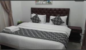 a bedroom with a large bed with a black headboard at Pyramiza Hotel Al Mangaf فندق بيراميـــزا المنقف in Kuwait