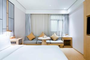 een hotelkamer met een bed en een bank bij JI Hotel Shanghai Huangpu Riverside South Xizang Road in Shanghai +26 foto's