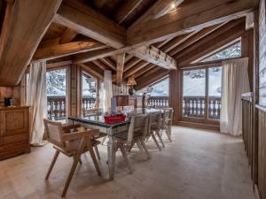 una sala da pranzo con tavolo e sedie di Chalet à Courchevel avec piscine, jacuzzi et vue panoramique - FR-1-613A-13 a Courchevel