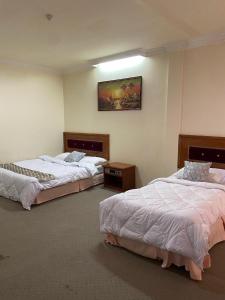 a room with two beds and a painting on the wall at SURIA HOTEL SDN BHD in Kota Bharu