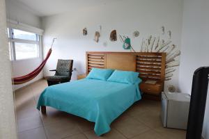 una camera da letto con un letto con un copriletto blu di Hotel Portobelo Guatape a Guatapé