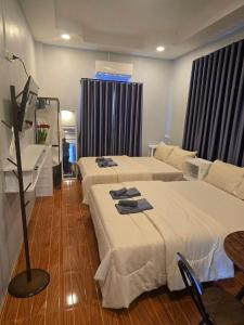 ein Hotelzimmer mit zwei Betten und einem Waschbecken in der Unterkunft Chaba4-1 in Ban Nong Bua Noi