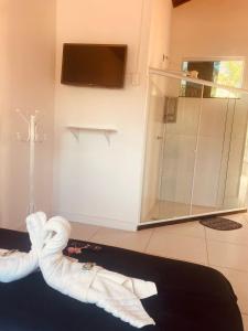 a person wearing white socks in a bathroom with a shower at Pousada Costa Mar in Rio das Ostras