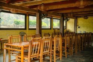 una sala da pranzo con un lungo tavolo e sedie di Mai Chau Villas a Mai Châu