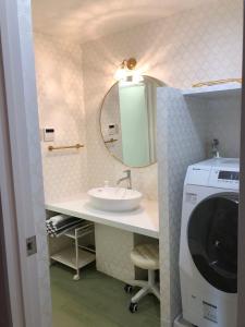 a bathroom with a sink and a washing machine at Mariposa Sea and Starry Garden Villa in Ishigaki Island