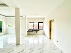 an empty living room with white walls and a window at Behomy Waru Sidoarjo in Djanti