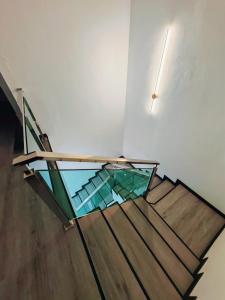 a staircase with a glass railing and a light on the wall at Zzora Home 28 in Alor Setar +1 photo