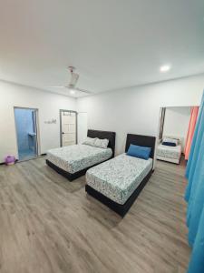 a room with two beds and a mirror at Zzora Home 28 in Alor Setar