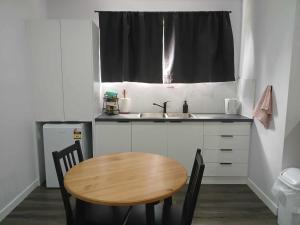 a small kitchen with a wooden table and a sink at Curra Cottage in Curra