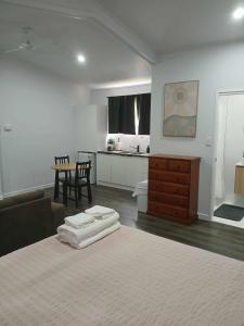 a bedroom with a bed and a table and a kitchen at Curra Cottage in Curra