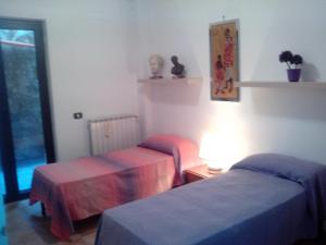 a bedroom with two beds and a table with a lamp at Villa Oasi in Gaeta +31 photos