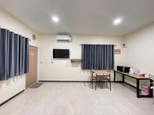 a waiting room with a table and a tv in a room at ช้อนเงินรีสอร์ท in Chachoengsao
