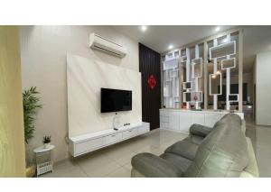 a living room with a couch and a flat screen tv at Permai Homestay King in Bukit Mertajam