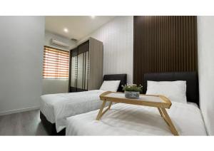 a hotel room with two beds and a table at Permai Homestay King in Bukit Mertajam