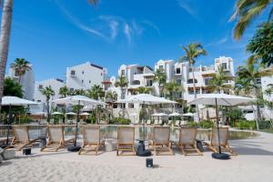 a row of chairs and umbrellas on the beach at a resort at Casa Nima by Lumina in San José del Cabo