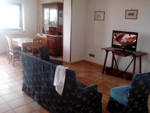 a living room with a couch and a table with a television at Villa Oasi in Gaeta
