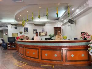 a man and woman standing behind a bar in a salon at SURIA HOTEL SDN BHD in Kota Bharu