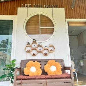 Ban Lak UanにあるLee Red Houseの赤い家の前のベンチ