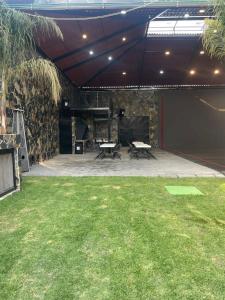 a patio with two picnic tables and a piano at Casa las palmerasmeras in Chalco de Díaz Covarrubias