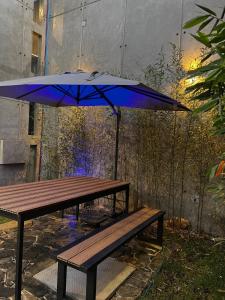 a blue umbrella sitting next to a wooden bench at Casa las palmerasmeras in Chalco de Díaz Covarrubias