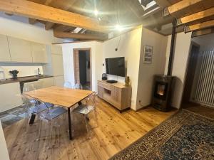 a living room with a wooden table and a kitchen at Cervinia House - Alpine Apartments & Chalet in Valtournenche