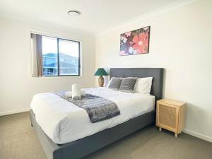 Un dormitorio con una cama grande y una ventana. en Kellyville Adorable 5 Br Home near Parks & Shops, en Kellyville 10 fotos más