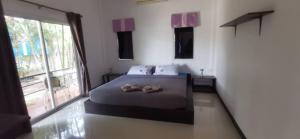 a bedroom with a bed with two slippers on it at Little Purple House 2- AoNang in Ao Nang 