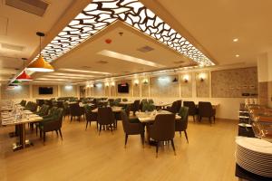 a restaurant with tables and chairs in a room at EMILYS By JDANIELS in Trivandrum