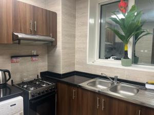 a kitchen with a sink and a stove and a window at Oasis tower family apartment 2302 in Ajman 