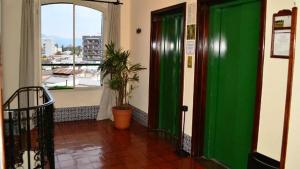 a hallway with a green door and a window at Hotel Salta in Salta