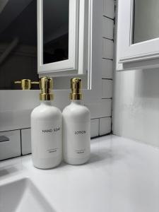 two bottles of hand soap sitting on a bathroom sink at Sunny Golden Hill Studio! Fully Stocked - near DT in San Diego