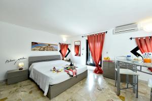 a bedroom with a bed with red curtains and a desk at B&B Vista Gallipoli in Alezio