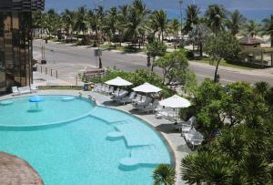 an overhead view of a swimming pool with chairs and umbrellas at Holiday Beach Hotel Danang in Da Nang