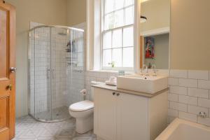 a bathroom with a toilet and a sink and a shower at DeWitt Apartment - 3 Red Doors Battery Point in Hobart