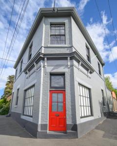 a house with a red door on a street at DeWitt Apartment - 3 Red Doors Battery Point in Hobart