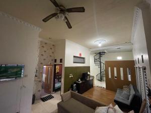 a living room with a couch and a ceiling fan at Tropica Villa, Kuningan in Jalaksana