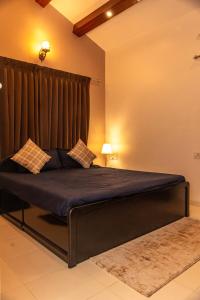 a bedroom with a large bed with a curtain at YOLO villa in Pirangut