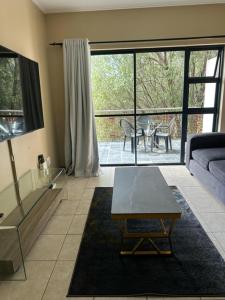 a living room with a couch and a table at Jackal Cosy One Bed in Roodepoort +11 photos