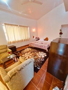 a living room with a bed and a couch at Dwarka By Natures Sweet Homes in Panchgani +16 photos