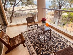 a living room with a table and chairs and a large window at Dwarka By Natures Sweet Homes in Panchgani