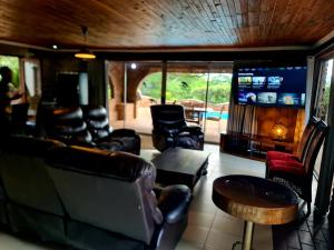 a living room with leather furniture and a television at The Farm in Hartbeespoort