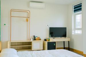 Vĩnh Cửu AnにあるKennal Homeのベッドとテレビ付きの机のある寝室