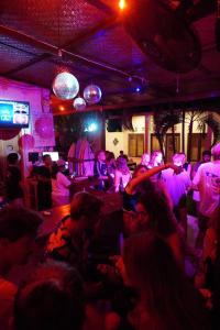 eine Gruppe von Menschen, die in einem Raum mit lila Lichtern tanzen in der Unterkunft Indonesia Backpacker Hostels in Kuta Lombok
