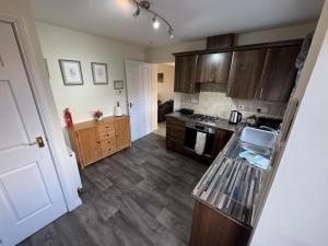 a kitchen with wooden cabinets and a counter top at No 25 Inverness - Home from Home in the Highlands in Inverness