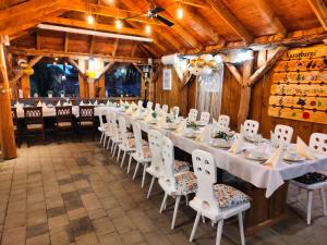 a long table in a room with white tables and chairs at Agroturystyka Zagroda Alpaka in Chmielno +86 photos