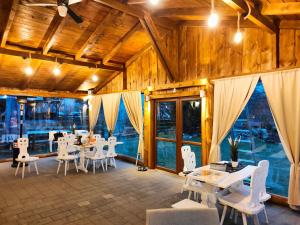 a dining room with white tables and white chairs at Agroturystyka Zagroda Alpaka in Chmielno