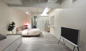 a bedroom with a bed and a flat screen tv at Wang Lang Hostel in Bangkok