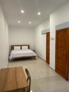 une chambre avec un lit et une table en bois dans l'établissement Astika Asri Homestay, à Dalung